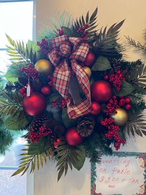 A christmas wreath with red and gold ornaments and berries