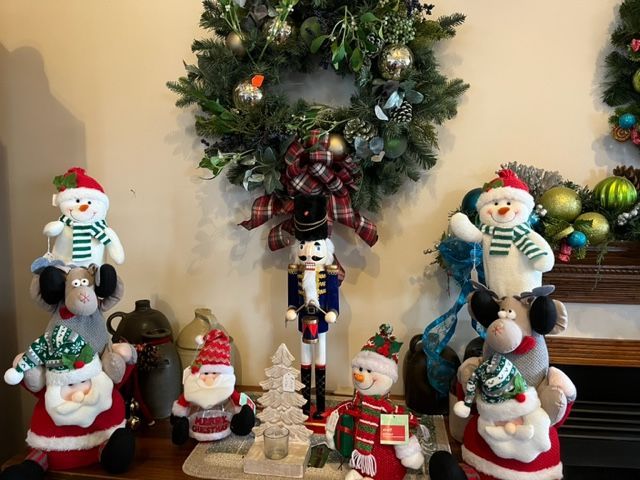 A group of christmas decorations are sitting on a table in front of a wreath.
