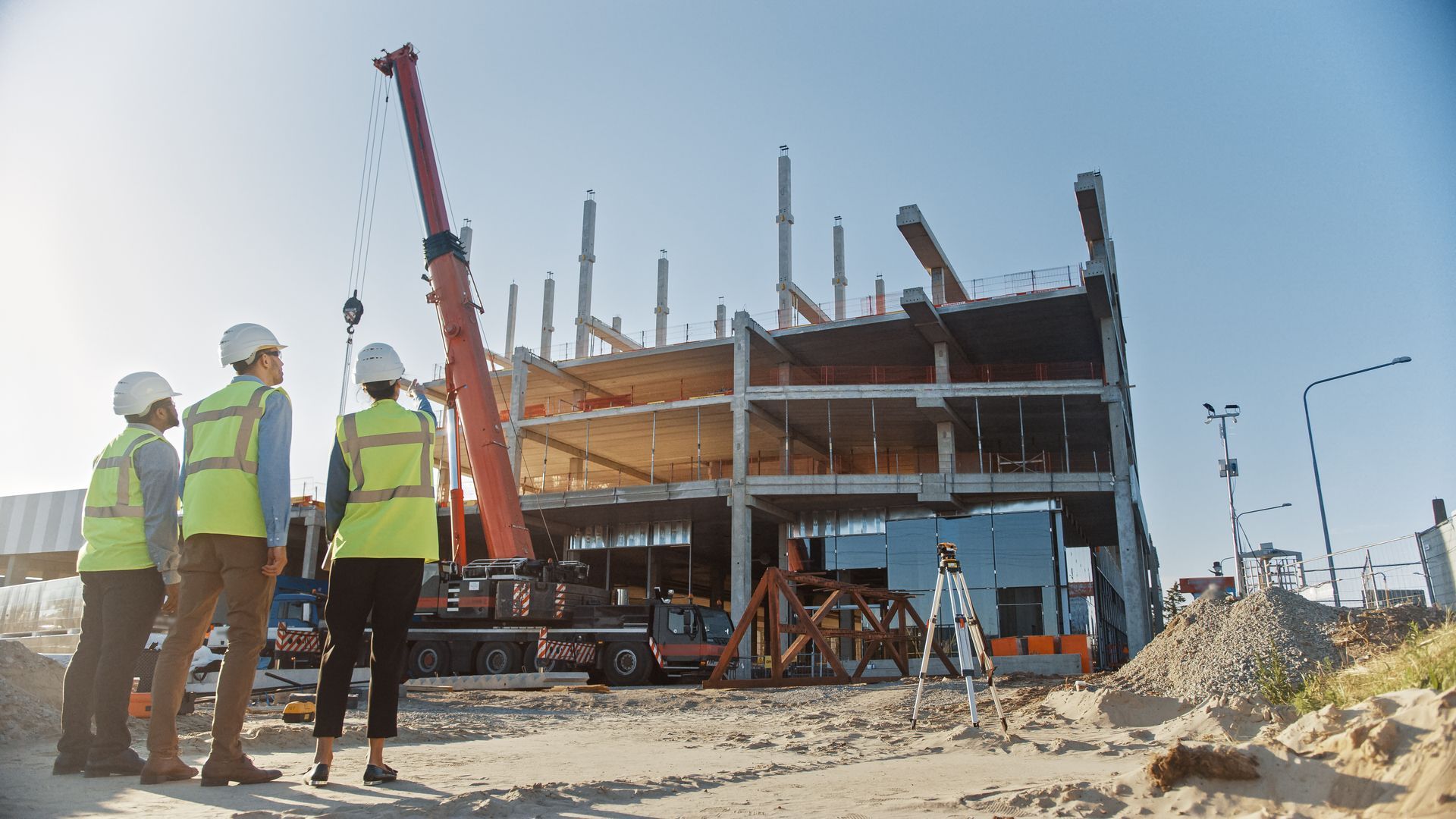 A group of construction workers are standing in front of a building under construction.