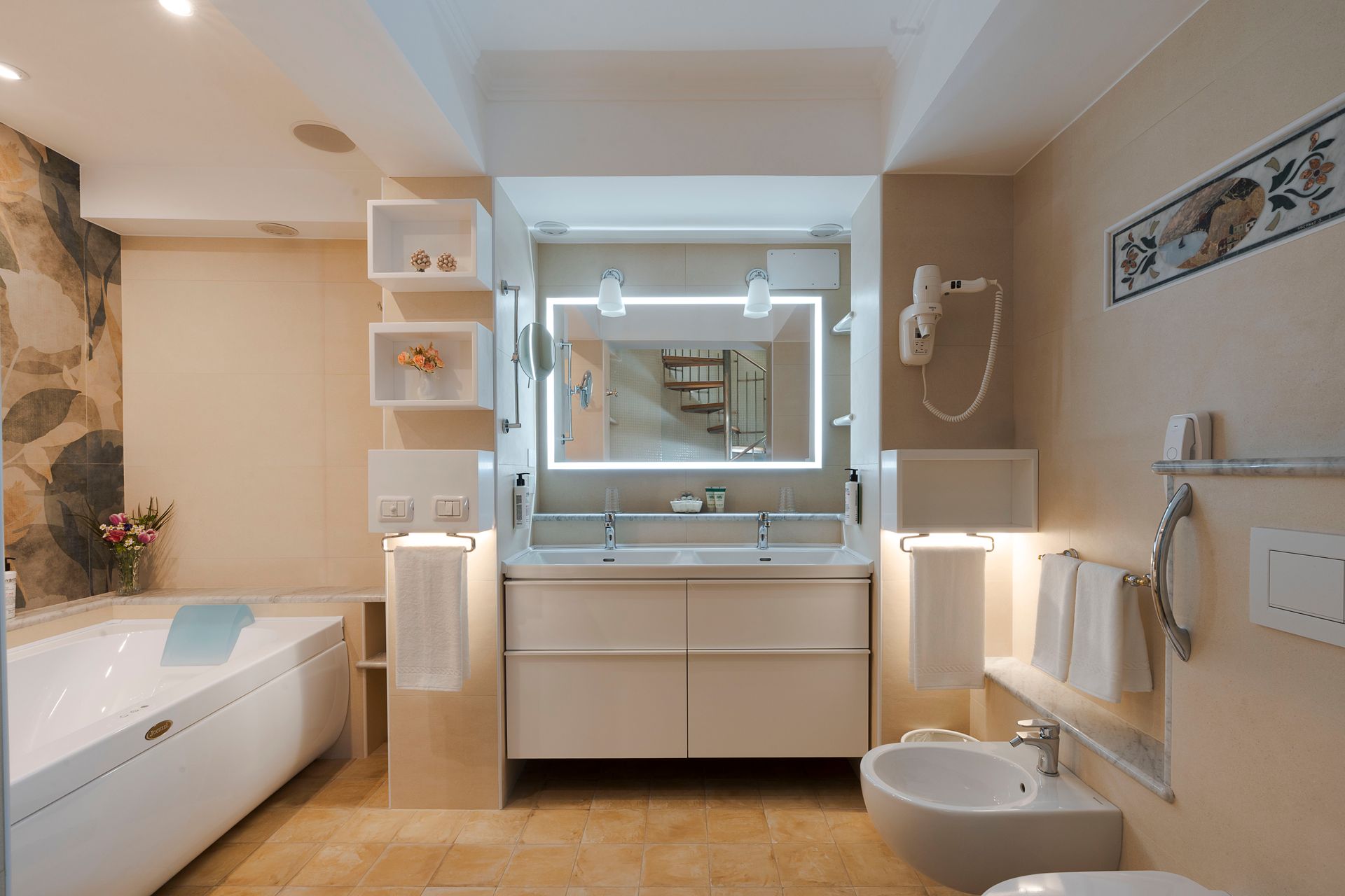 Modernes weißes Badezimmer mit Waschtisch, Spiegel, Badewanne und Toilette unter sanfter Beleuchtung