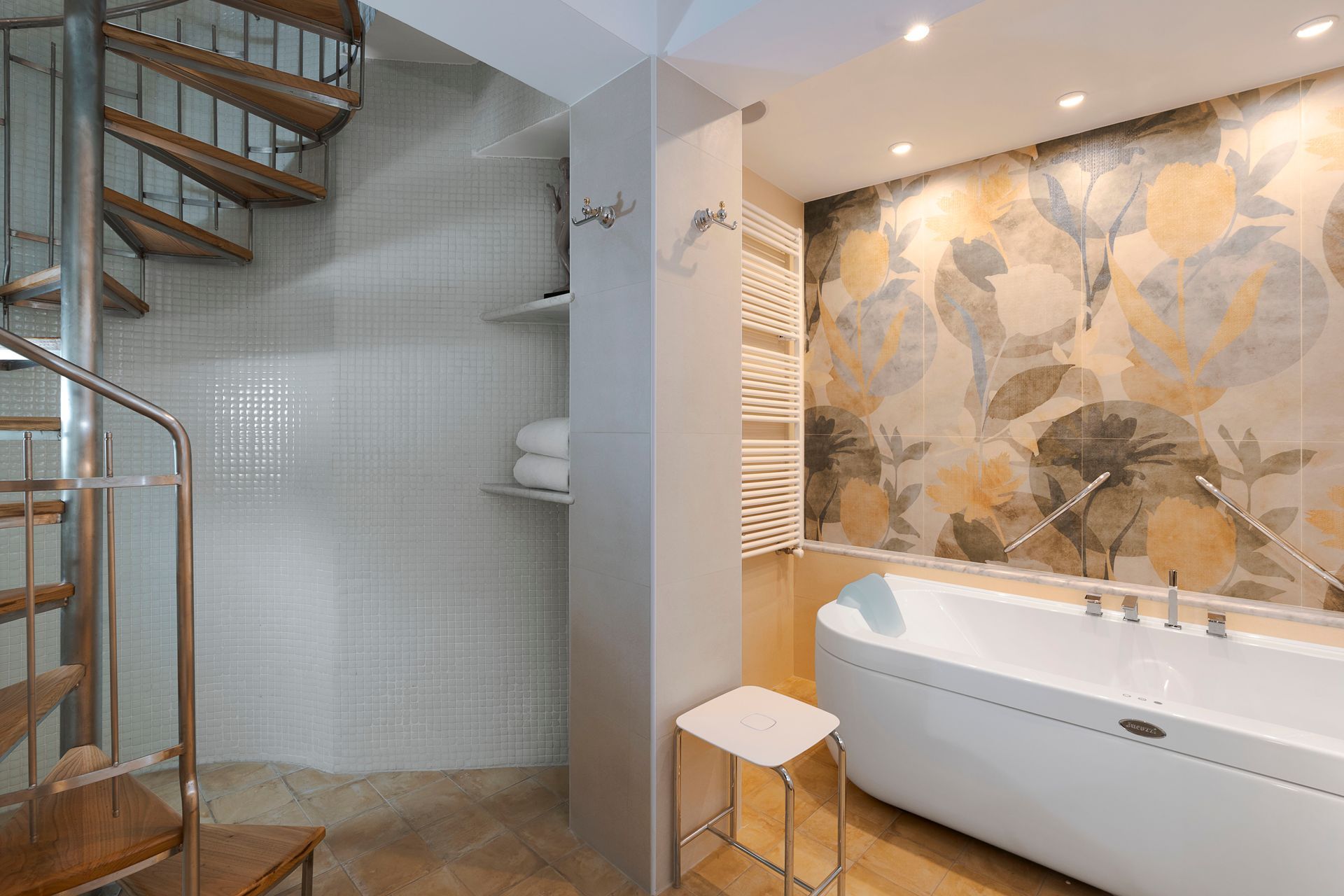 Modernes Badezimmer mit Wendeltreppe, gefliester Dusche und freistehender Badewanne vor floraler Tapete