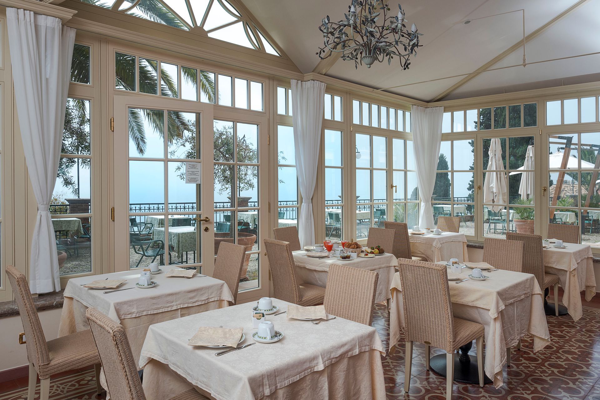 Elegantes Restaurant am Meer mit gedeckten Tischen und großen Fenstern mit Blick auf das Meer