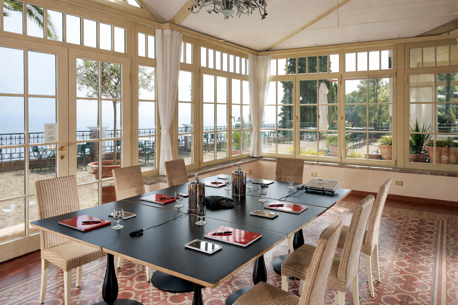 Helles Esszimmer mit großen Fenstern, schwarzem Tisch und Seeblick