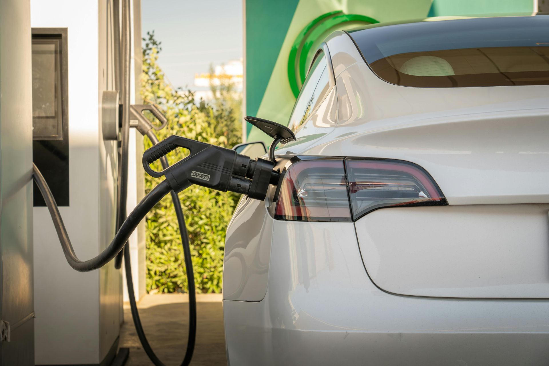 Voiture électrique blanche en charge à une borne extérieure