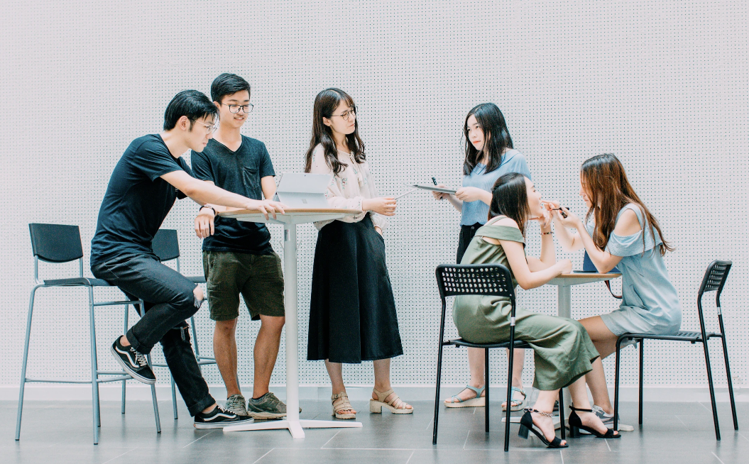 Group of people collaborating around a table in a modern setting.