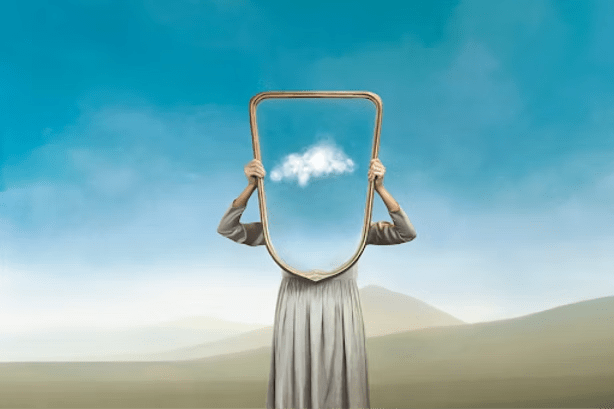 Person holding a mirror reflecting a blue sky with a cloud; setting is a desert landscape.