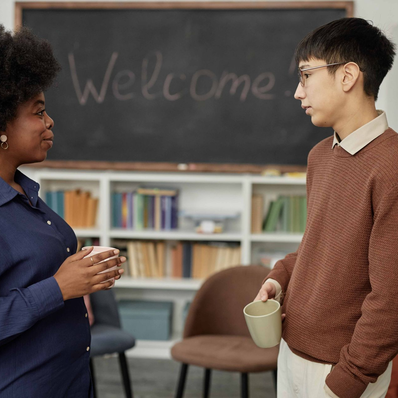Woman and man in front of a chalkboard that says