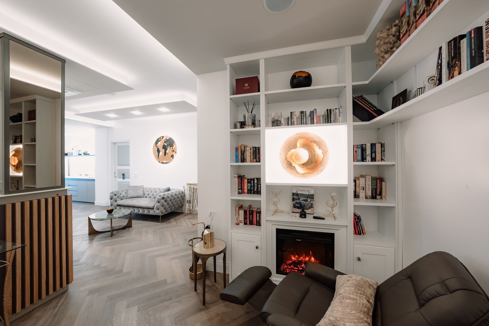 Soggiorno con librerie integrate, camino e un divano moderno, con una tavolozza di colori neutri.