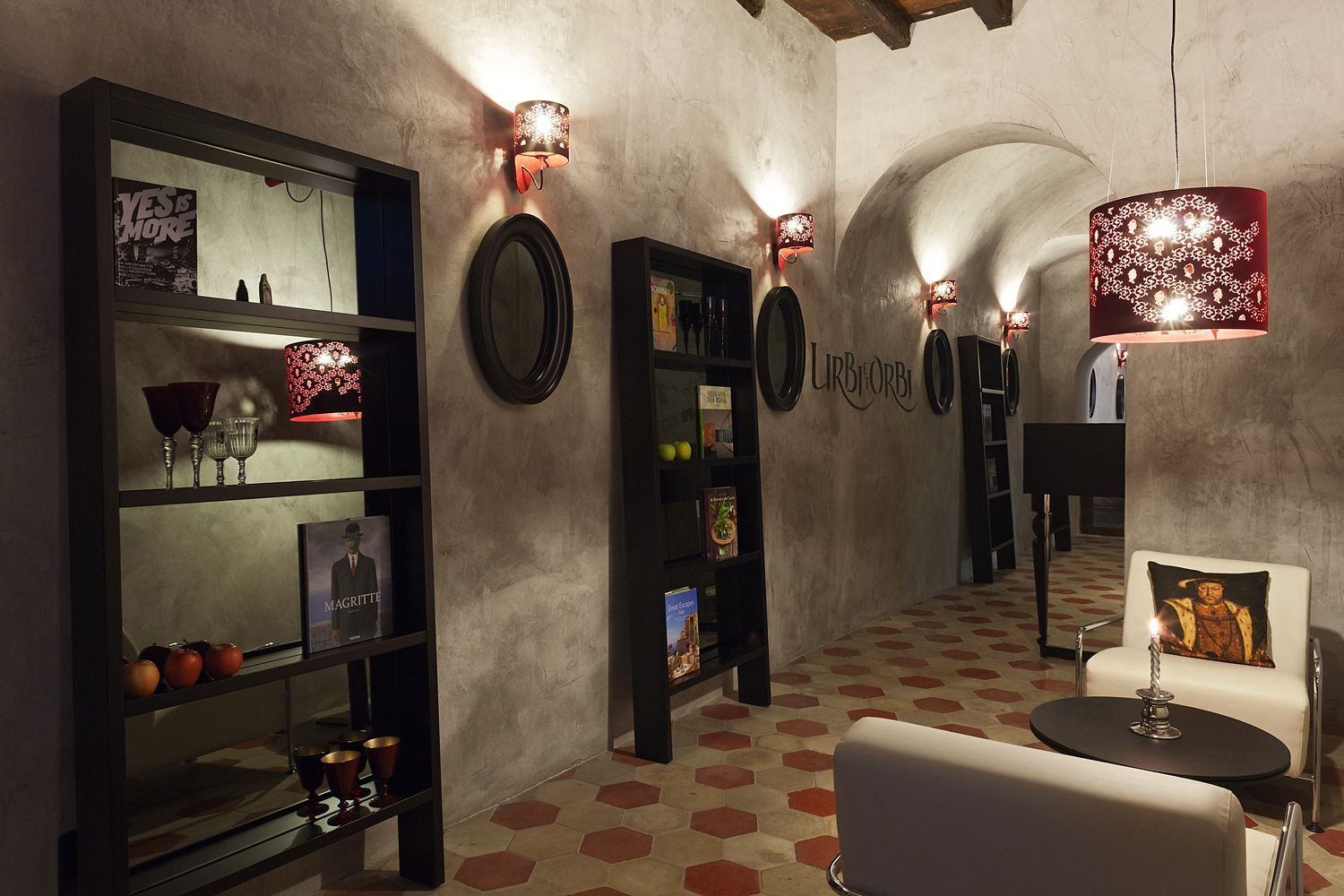 Interno con scaffali, sedute e luci decorative, in uno stile rustico e scarsamente illuminato, con ingressi ad arco.