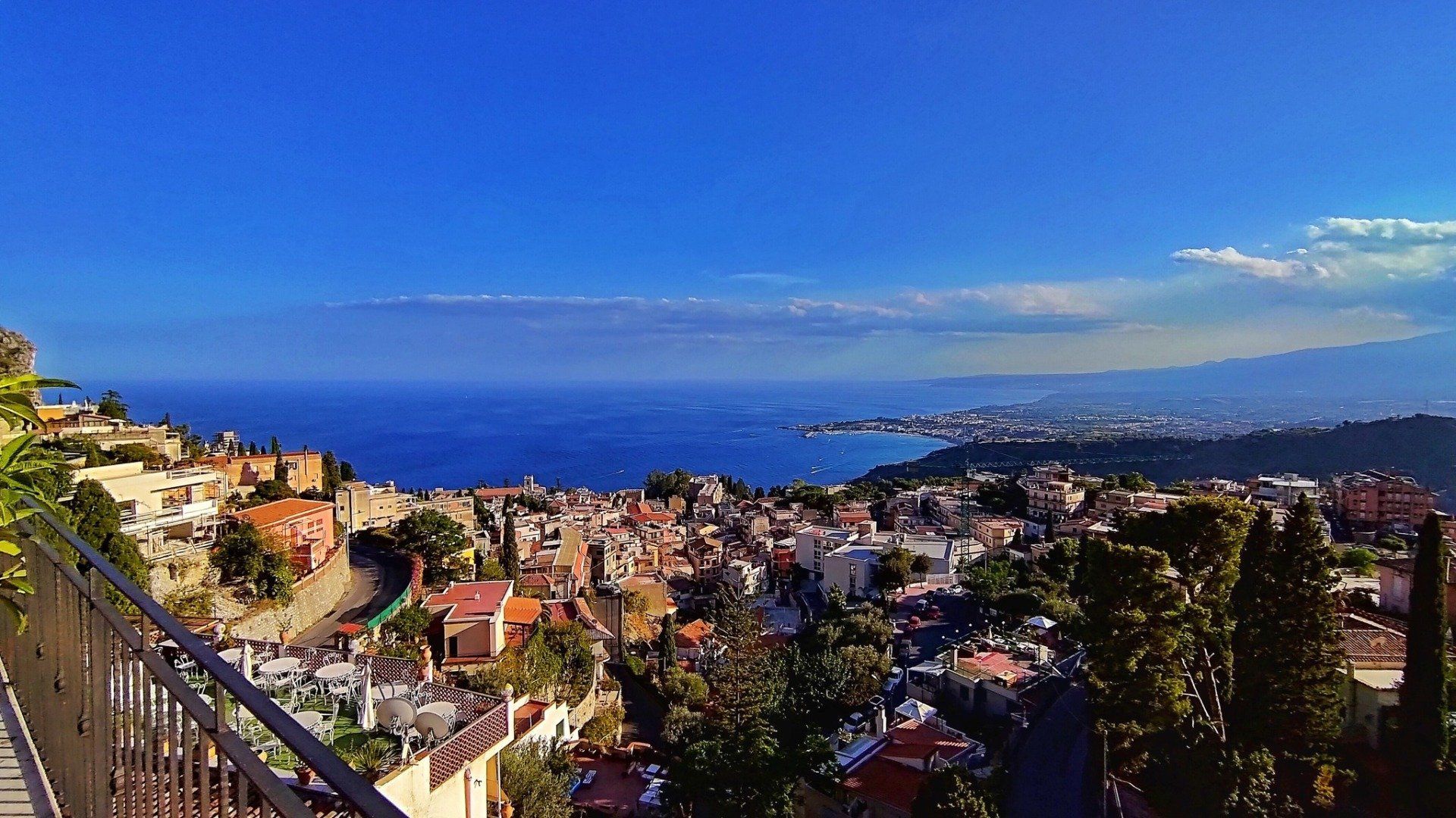 Una vista dall'alto di una città costiera in Italia con cielo azzurro e mare.
