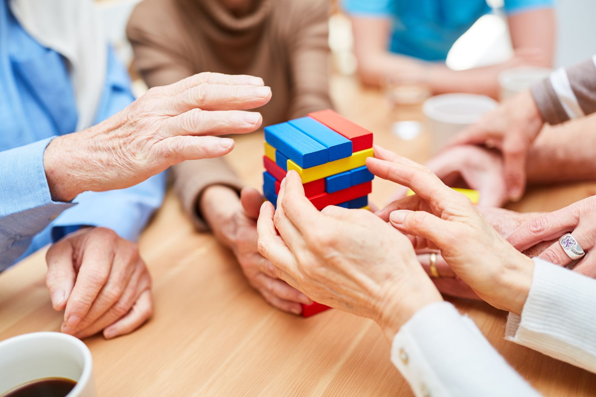 Hands solving a colorful block puzzle together at a table
