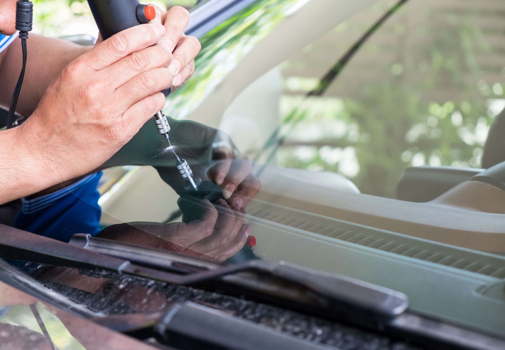 Car windshield being cleaned with a cloth and spray cleaner close-up