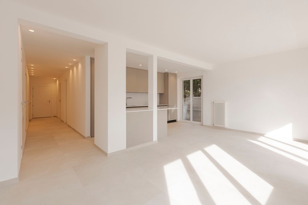 Empty, bright living space with a hallway, kitchen area, and sunlight streaming through windows — TMP Painting Services in Beaconsfield, QLD