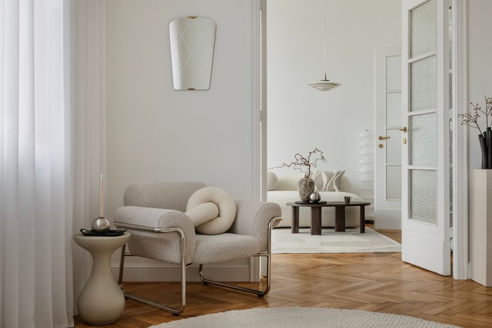Neutral-toned living room with an armchair, side table, and doorway leading to another room — TMP Painting Services in Beaconsfield, QLD