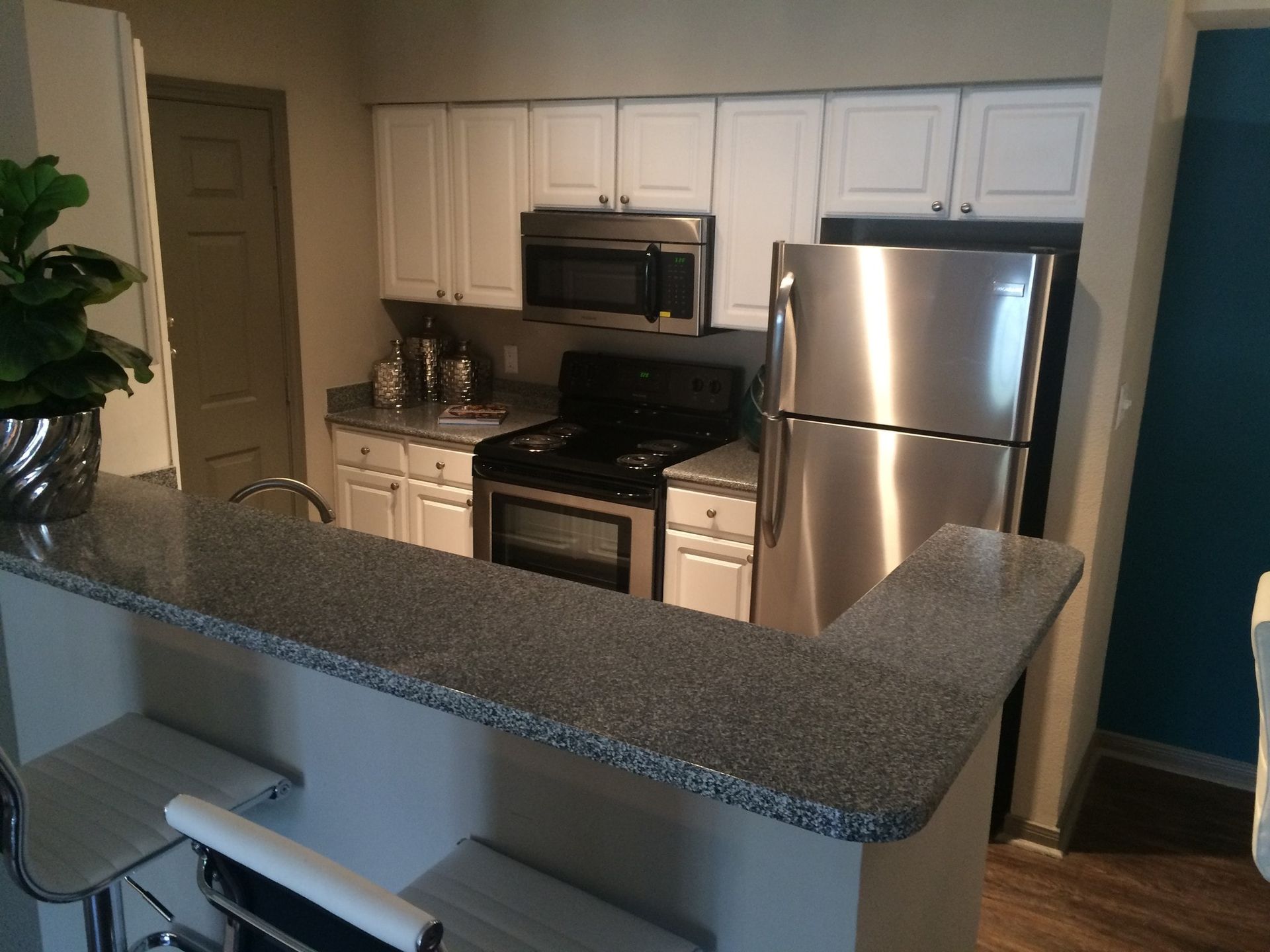 Kitchen with stainless steel appliances, white cabinets, and granite countertops.