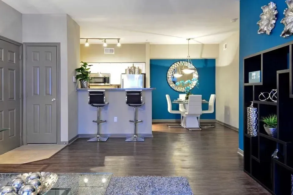 Open-concept apartment interior with kitchen island, bar seating, and dining area.