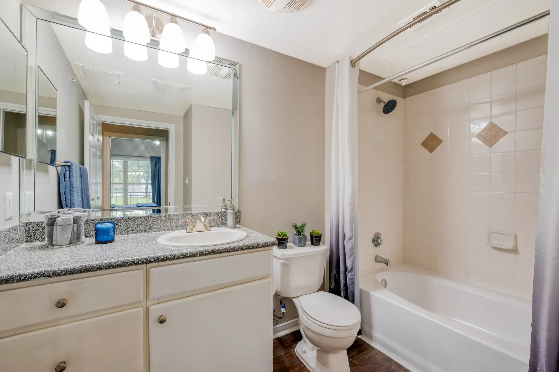 Bathroom with vanity, mirror, toilet, and a tub/shower combo.
