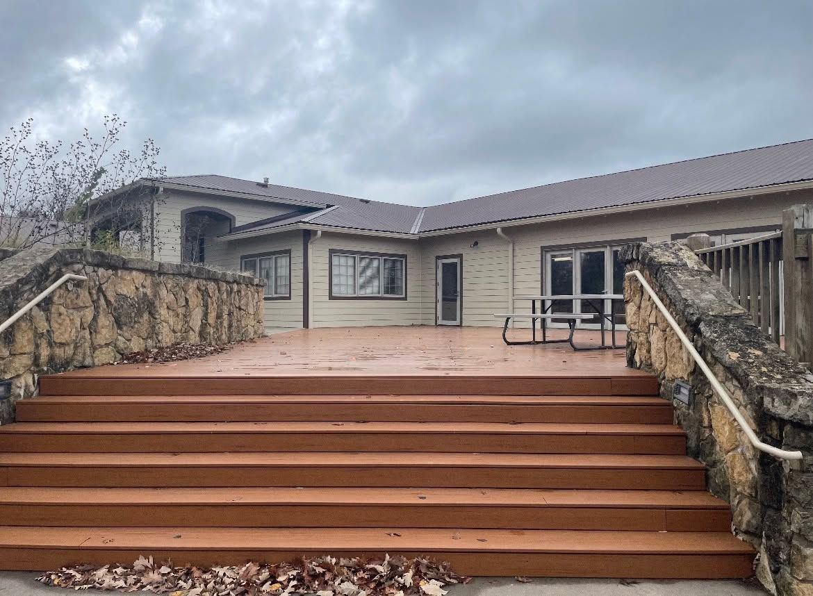 Stone stairway leading to a house entrance with a cloudy sky above