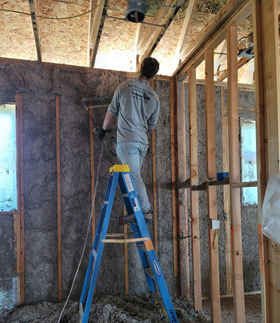 Person caulking a wooden door frame with a caulk gun.