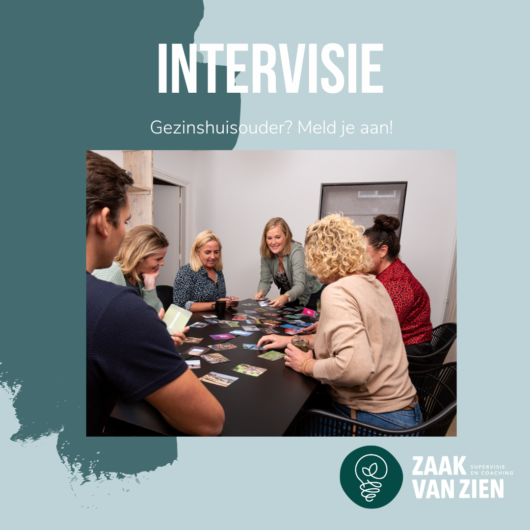 Een groep mensen zit rond een tafel tijdens een overlegsessie voor ouders in een gezinswoning, met kaarten verspreid over het tafelblad.