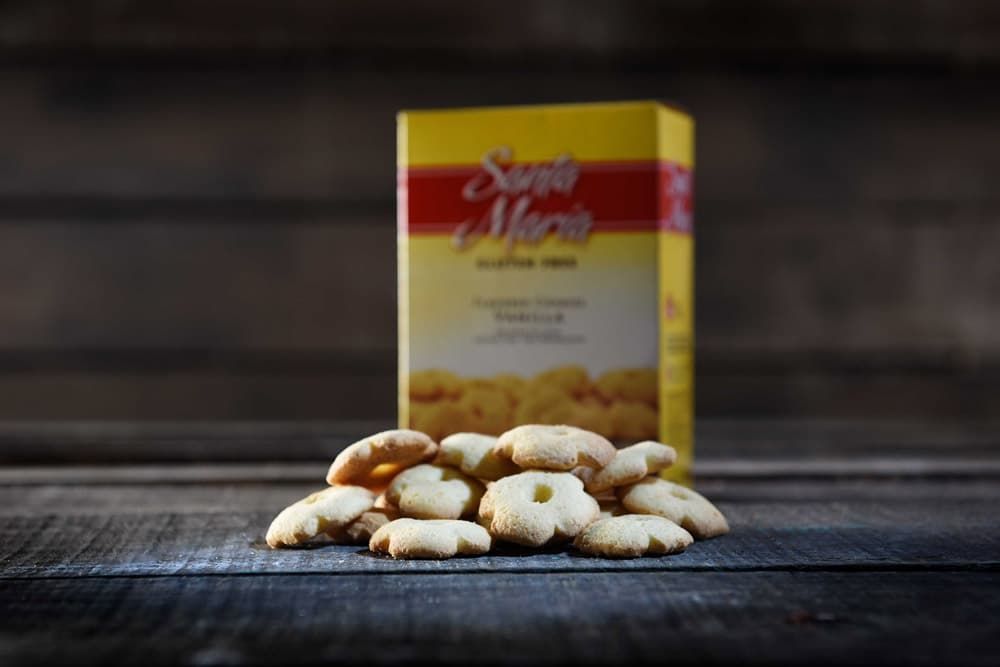 Un montón de galletas pequeñas con forma de flor reposa sobre una superficie