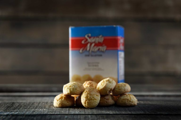Un pequeño montón de bolitas de queso doradas frente a una caja azul y roja