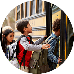 a group of children are boarding a school bus .