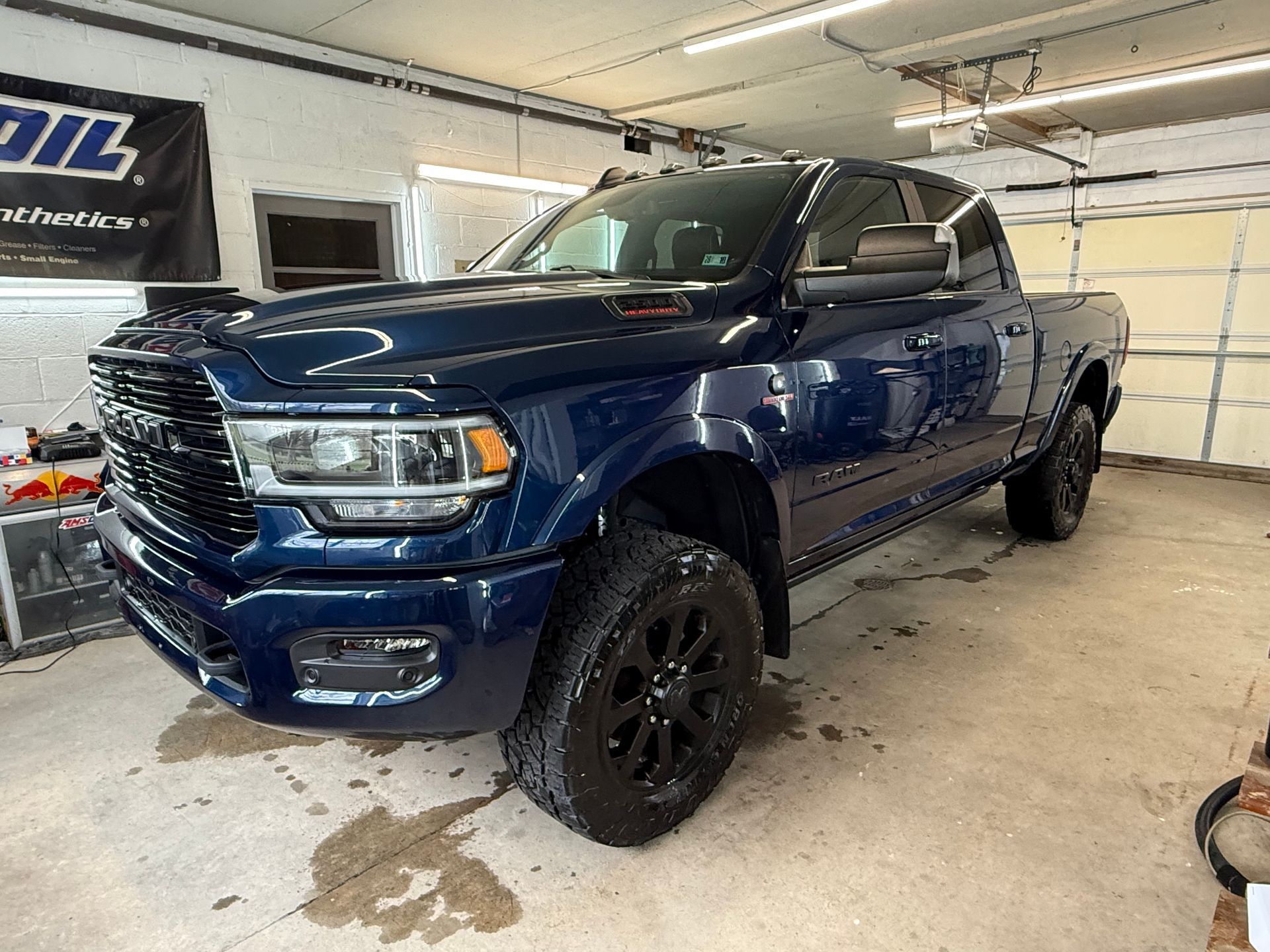Blue pickup truck in a garage, shown from the front-left side.
