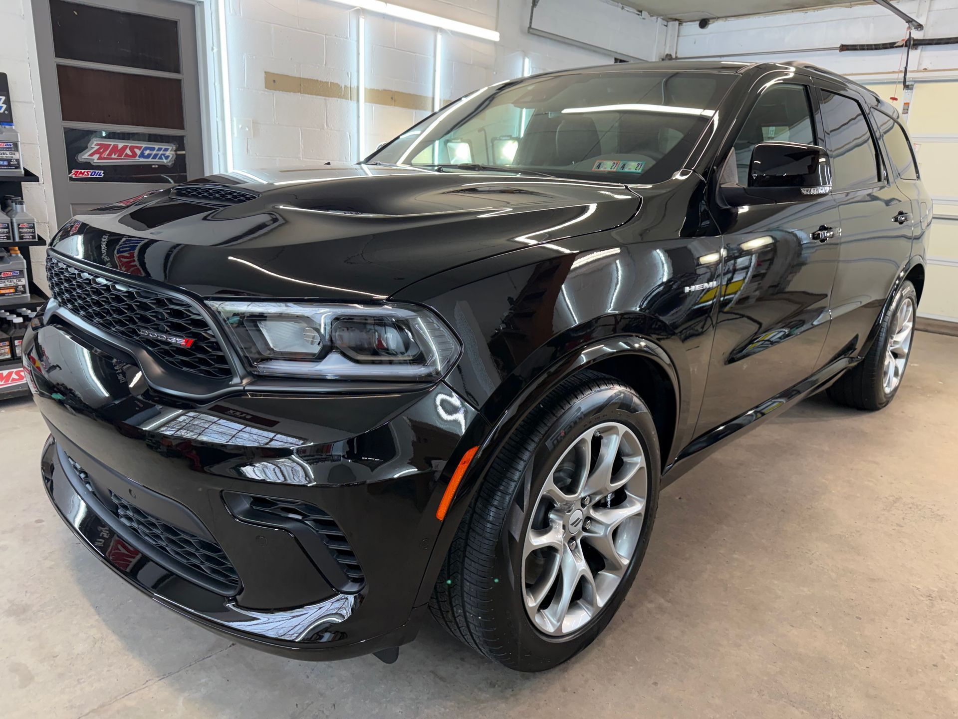 Black SUV parked indoors in a showroom, angled front-left view