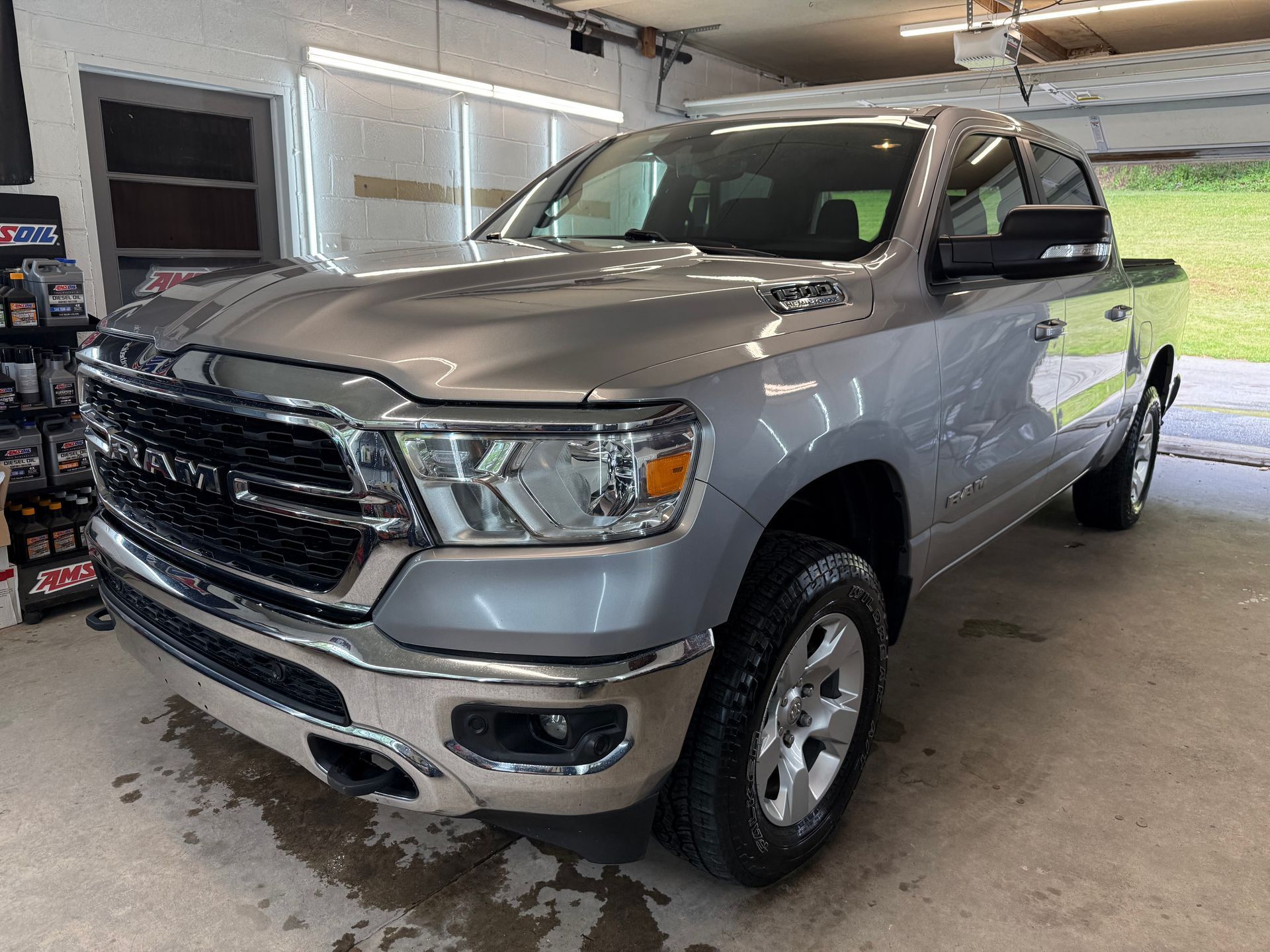 Silver pickup truck parked inside a garage, front-left view