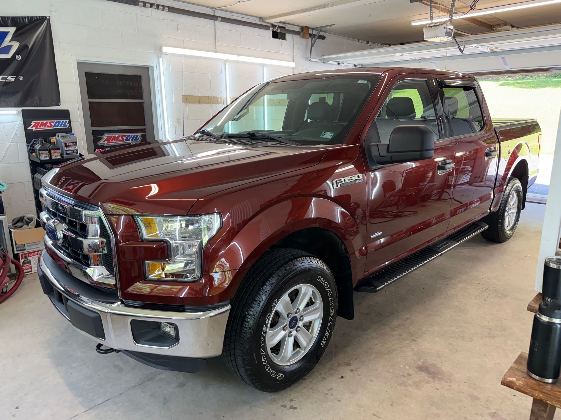 Maroon Ford pickup truck parked inside a garage showroom