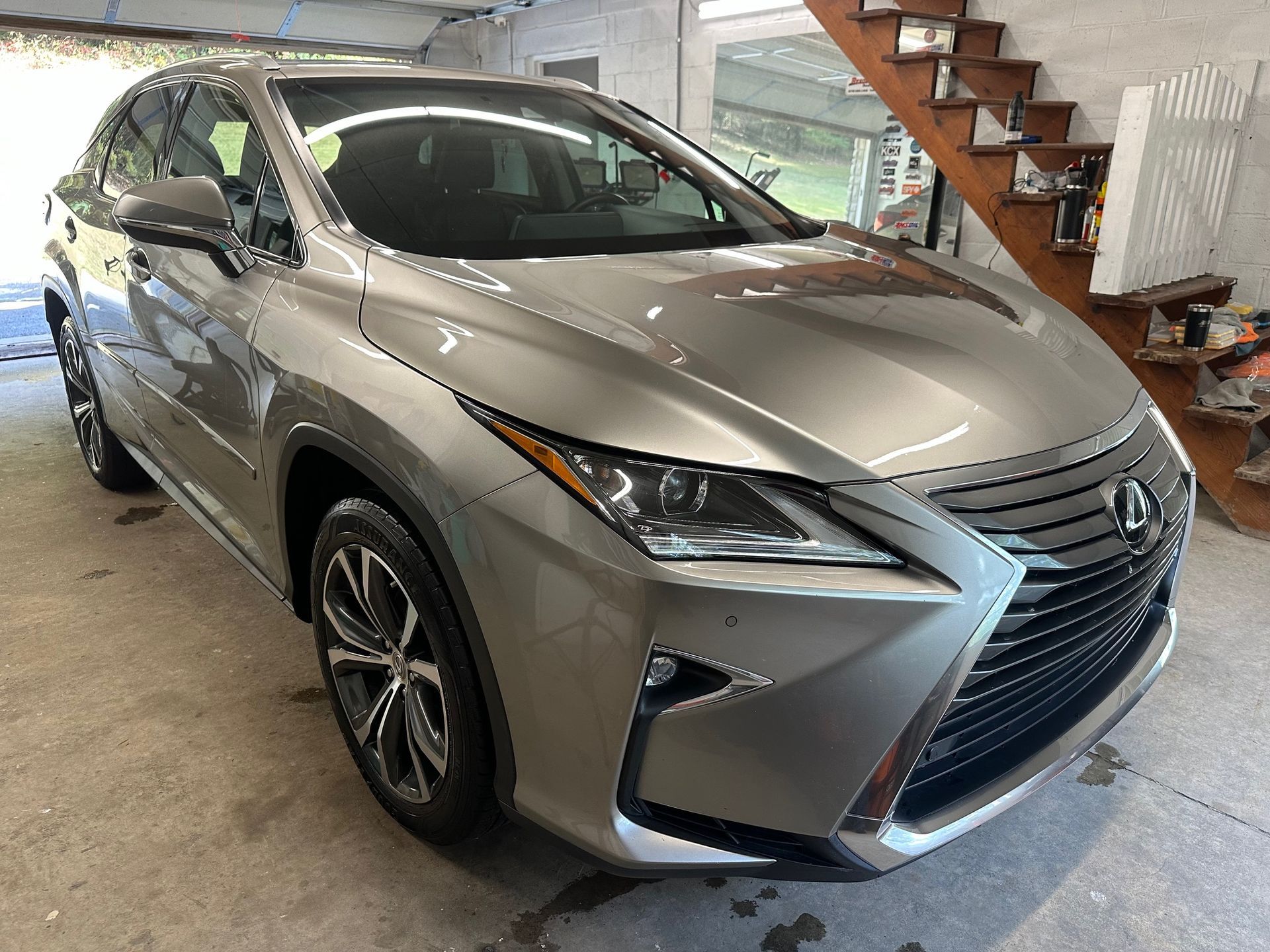 Silver Lexus RX SUV parked inside a garage.
