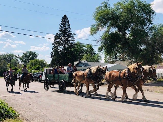 A group of people are riding in a horse drawn carriage.