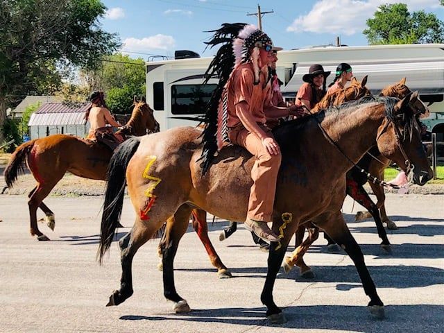 A group of people are riding horses down a street.