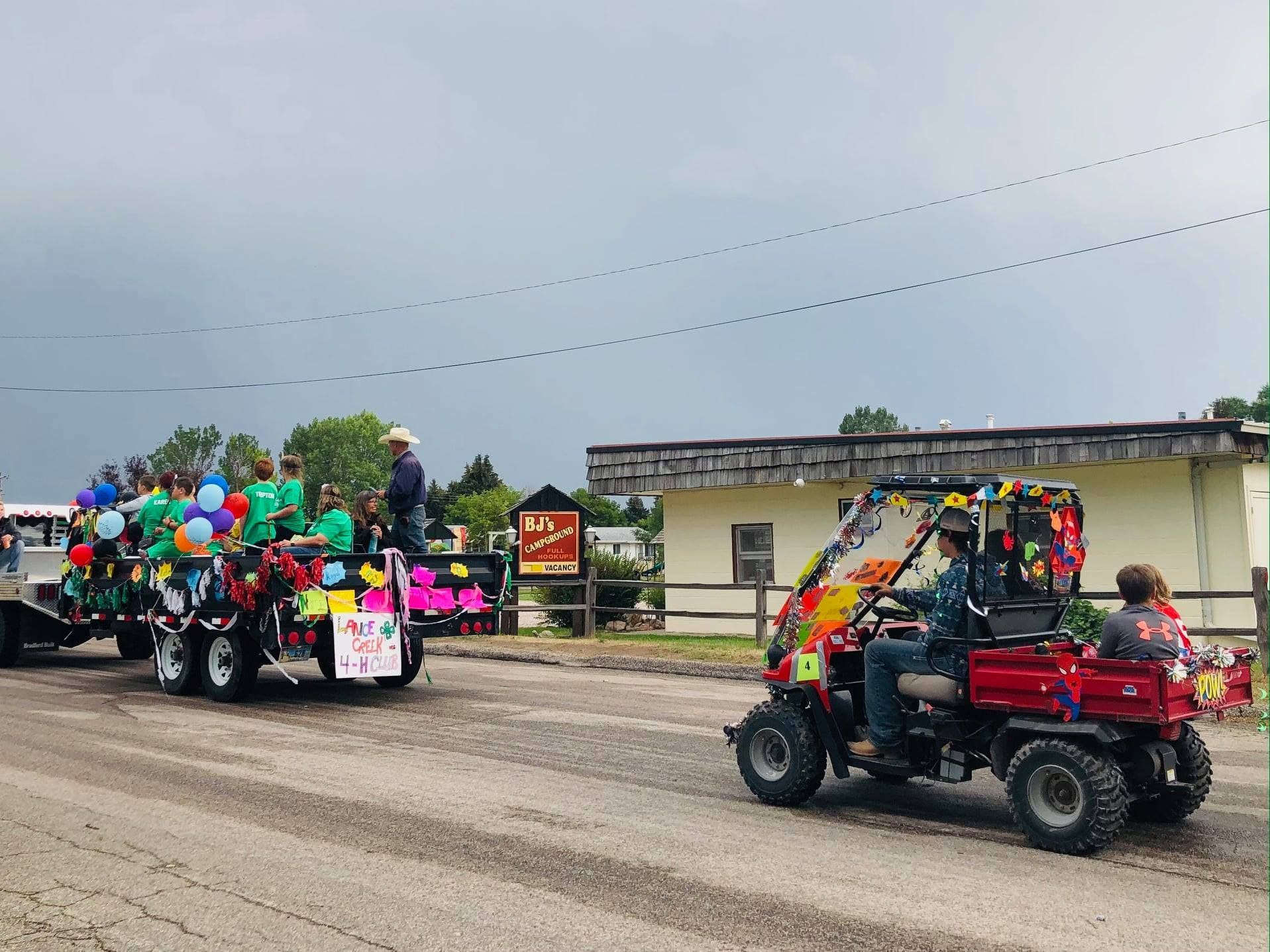 A group of people are riding in a parade in a red atv.
