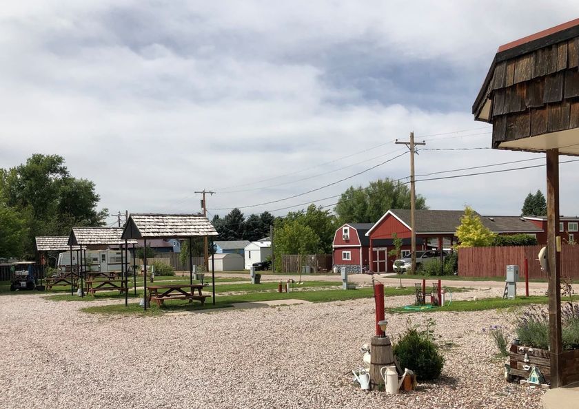 A gravel area with a red barn in the background