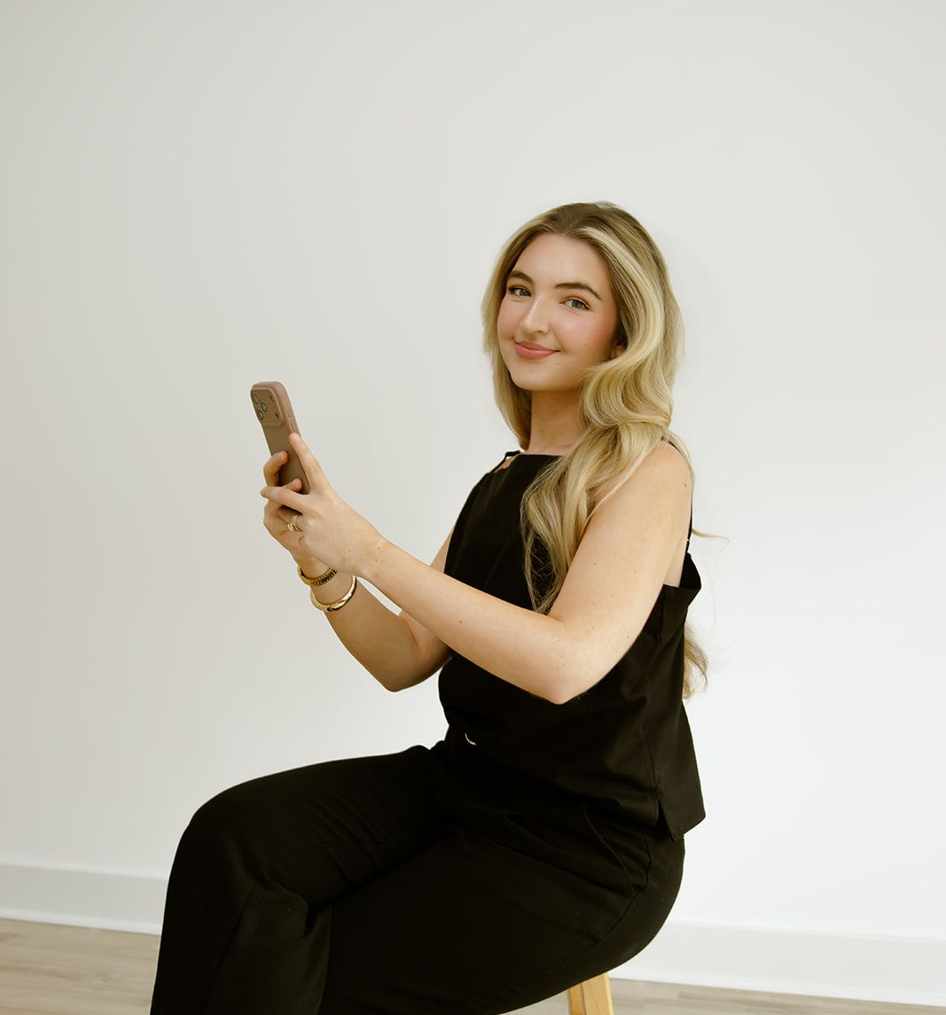 Hummingbird Media's social media strategist holding her phone smiling.
