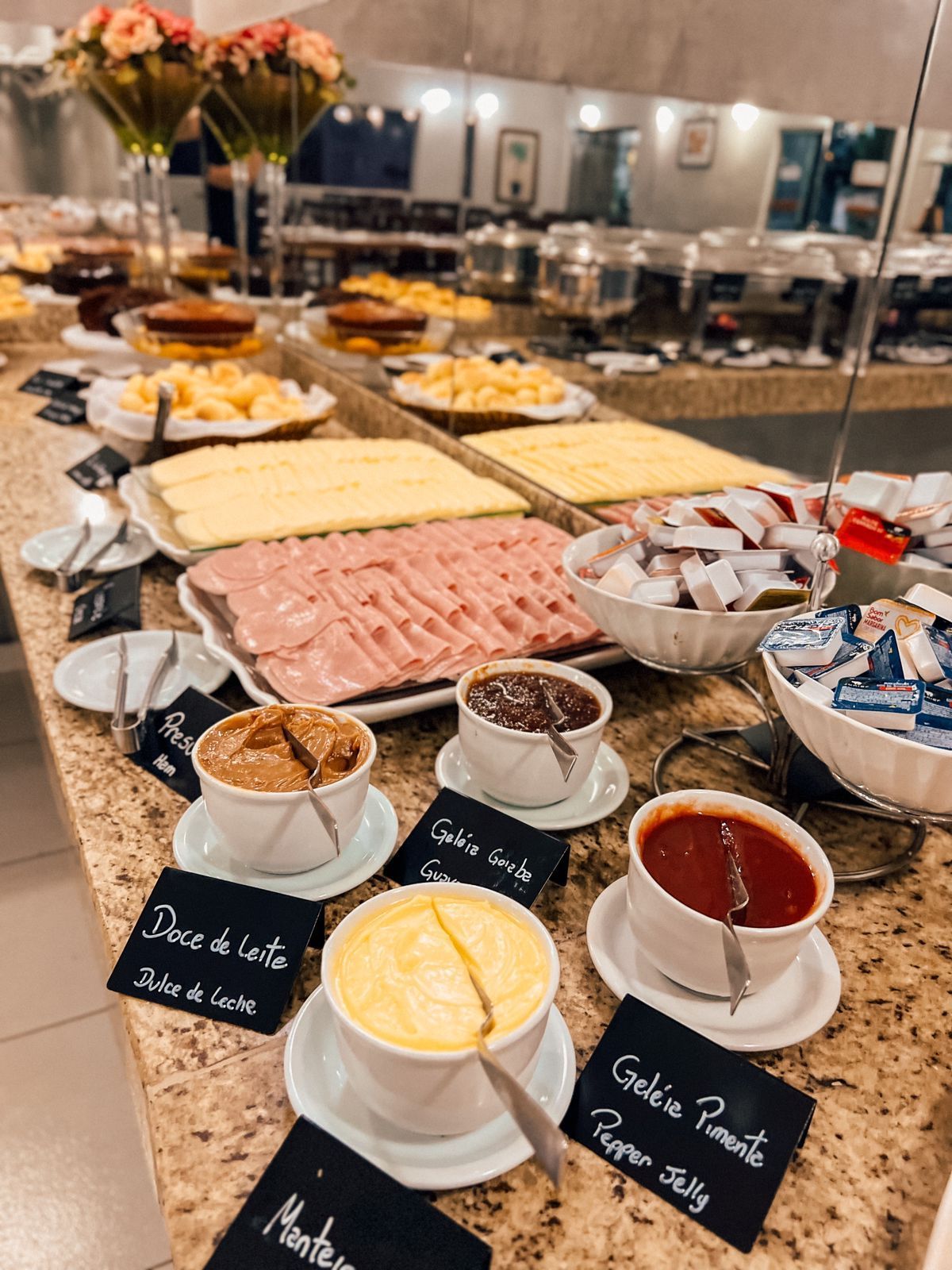 Um restaurante cheio de mesas e cadeiras e um bufê.