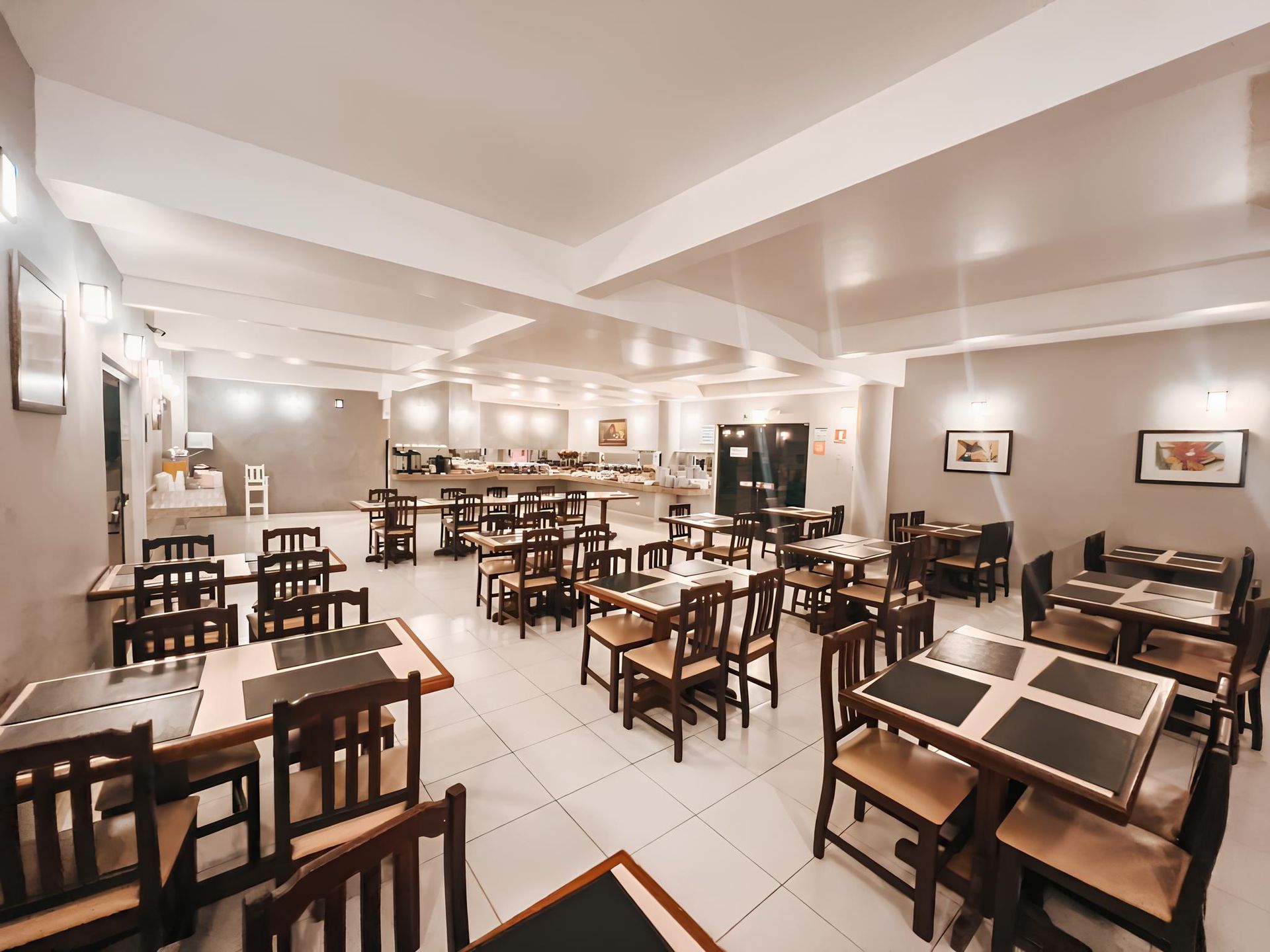 Uma grande sala de jantar com mesas e cadeiras em um restaurante.