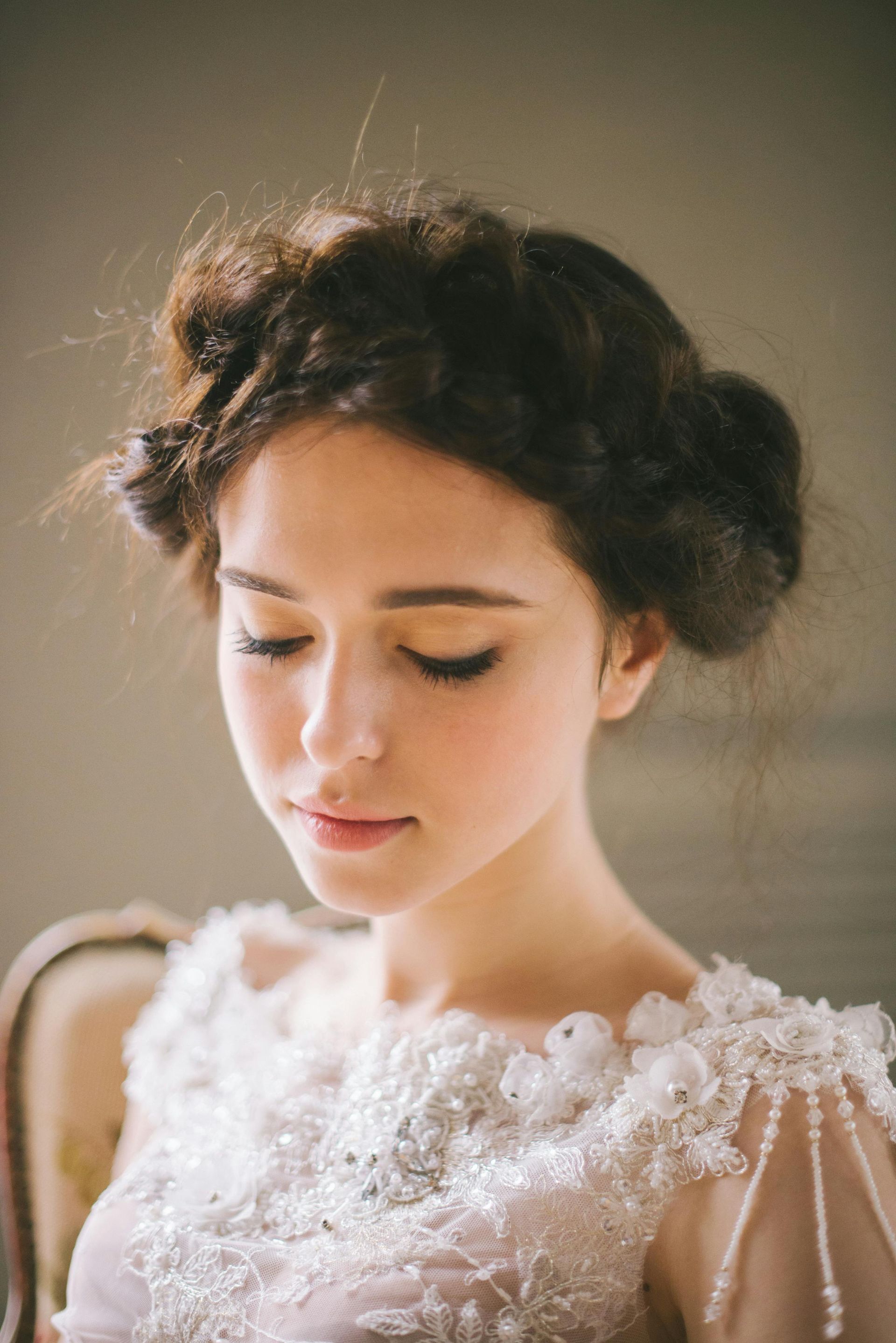 A woman in a wedding dress is sitting in a chair with her eyes closed.