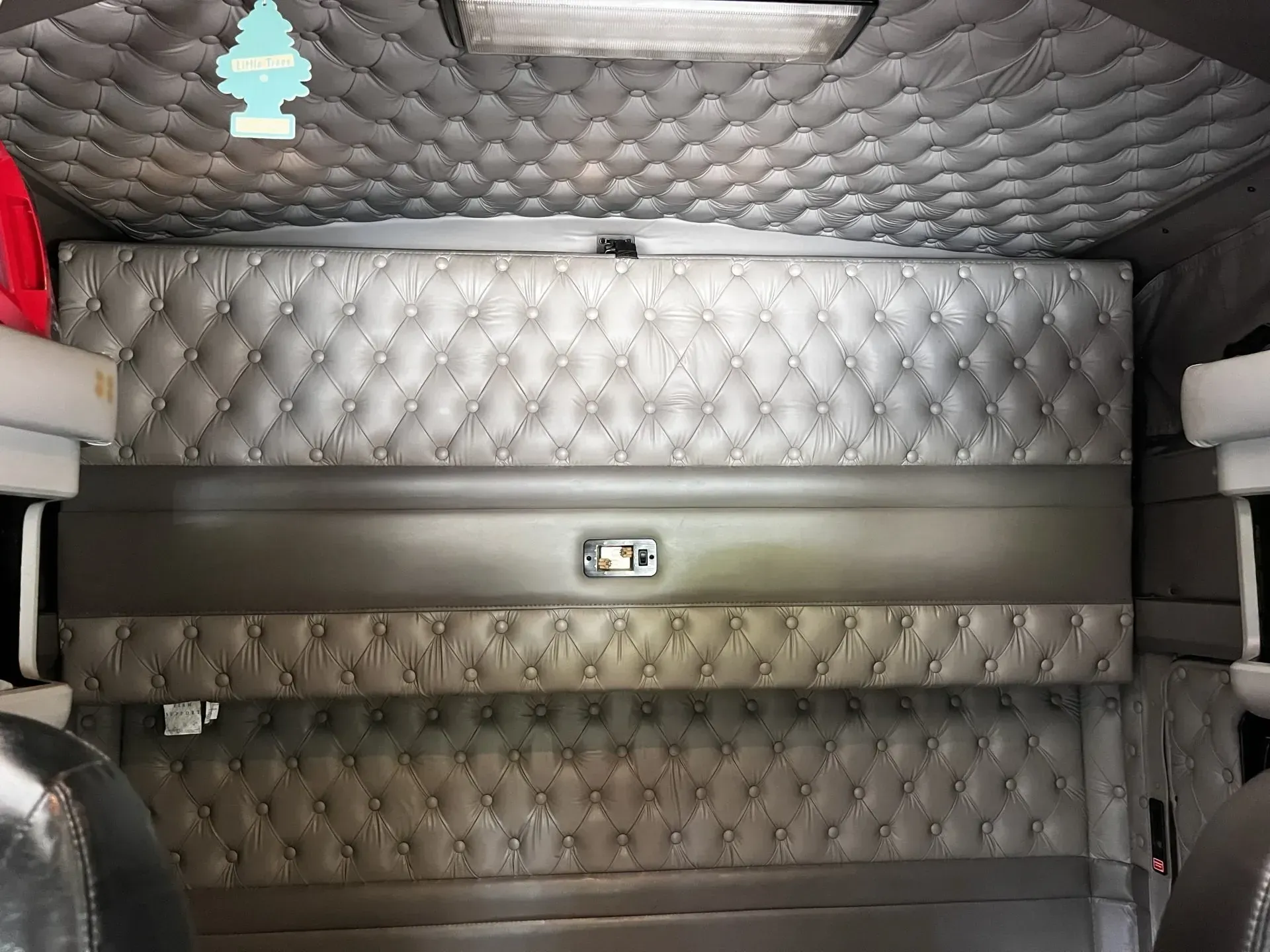 The inside of a semi truck with a bed and a ceiling.