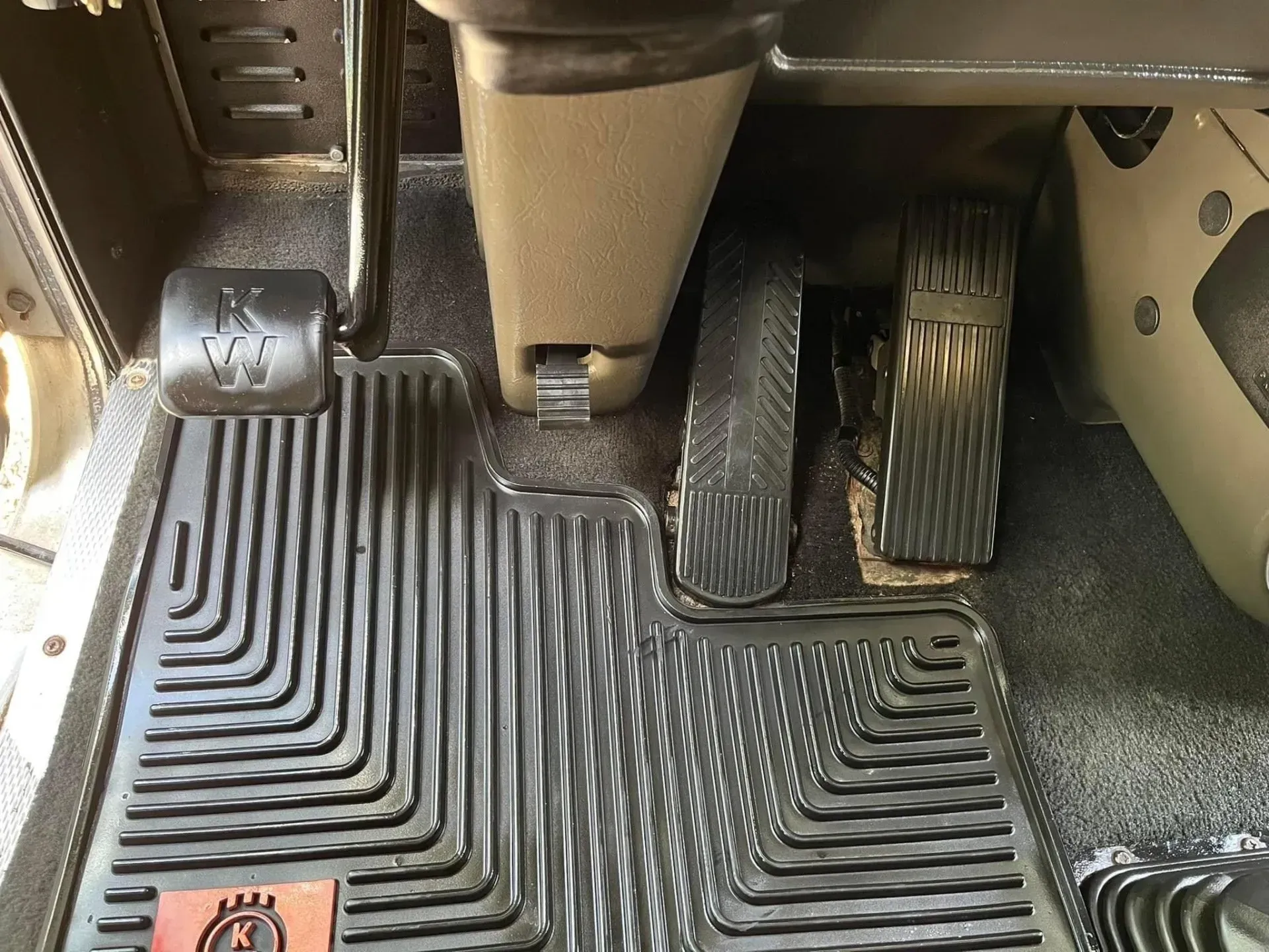 A close up of a rubber mat on the floor of a car.