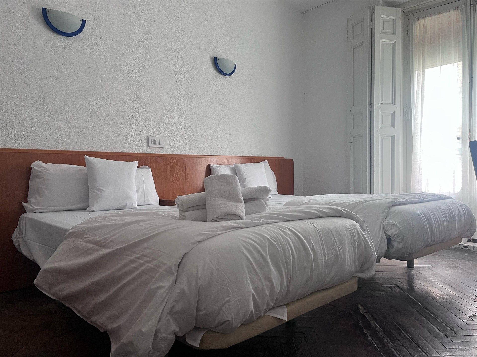 A hotel room with two beds and a window