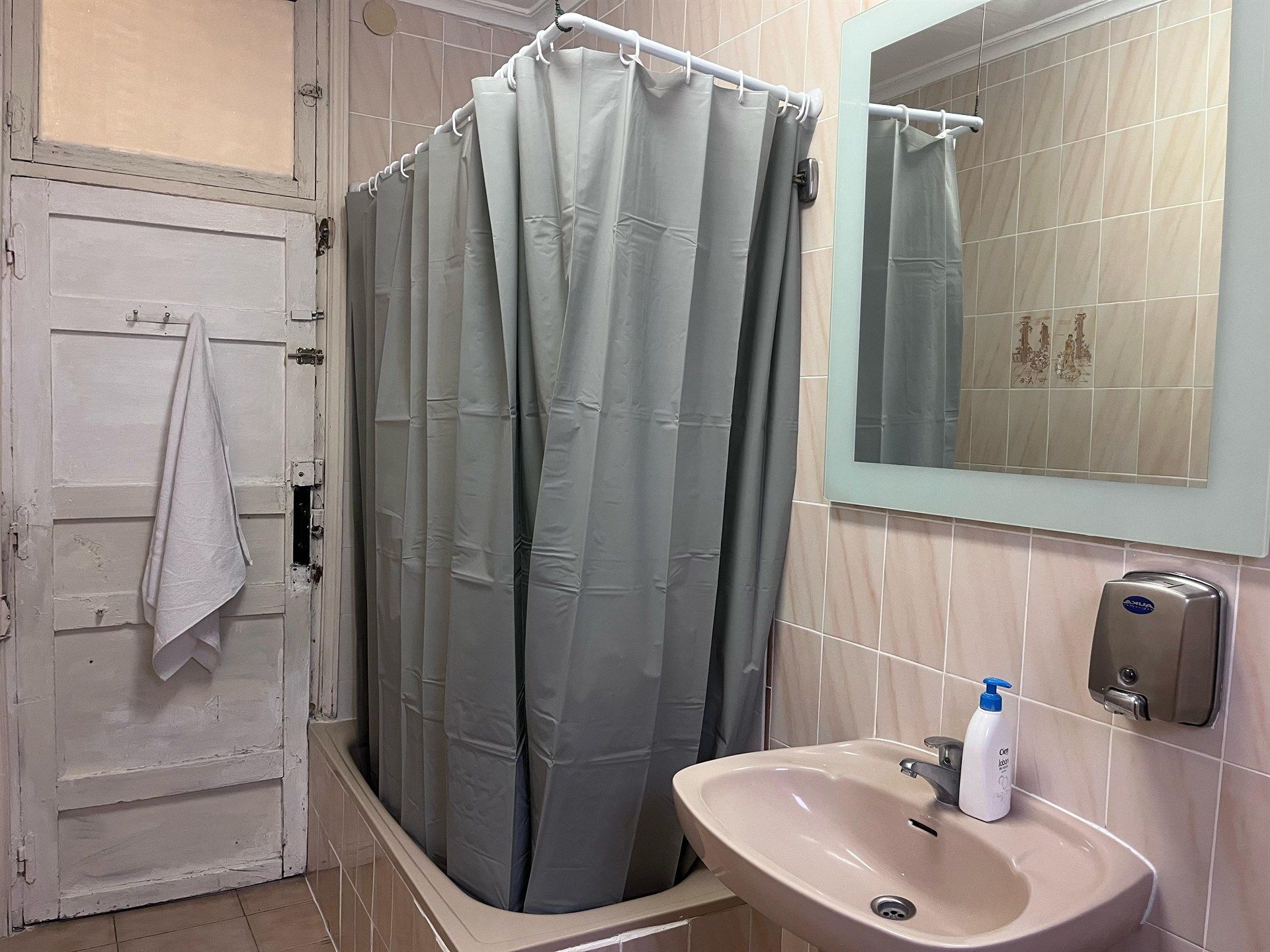 A bathroom with a sink a mirror and a shower curtain