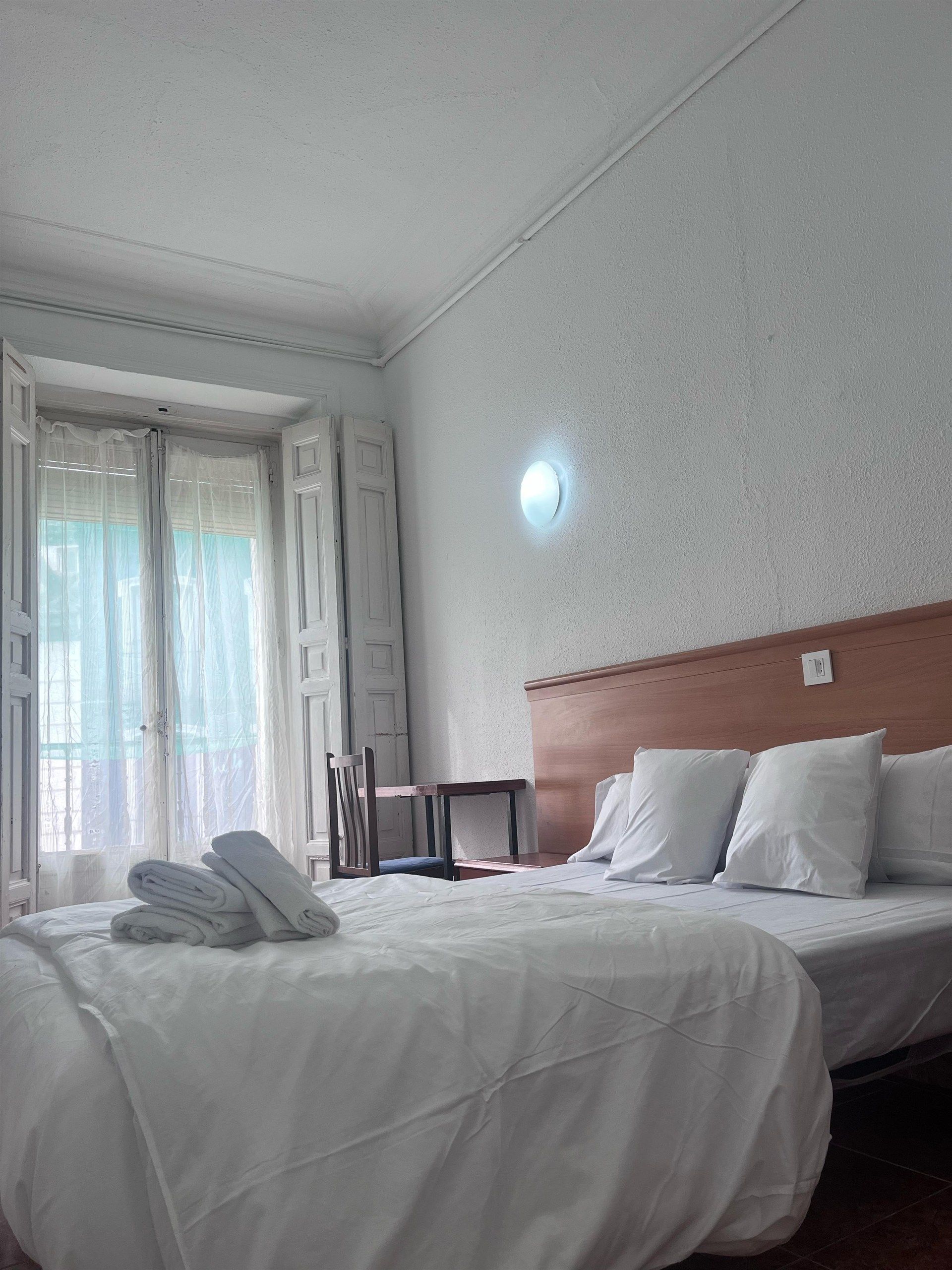 A hotel room with a large bed and a window