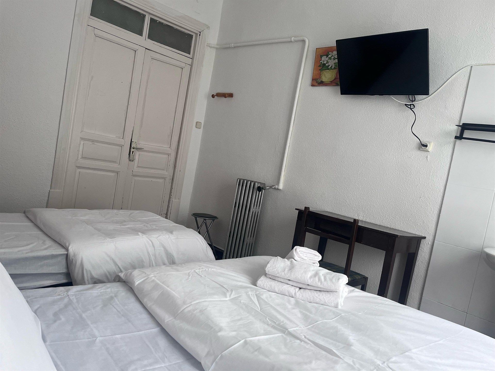 A hotel room with two beds and a flat screen tv