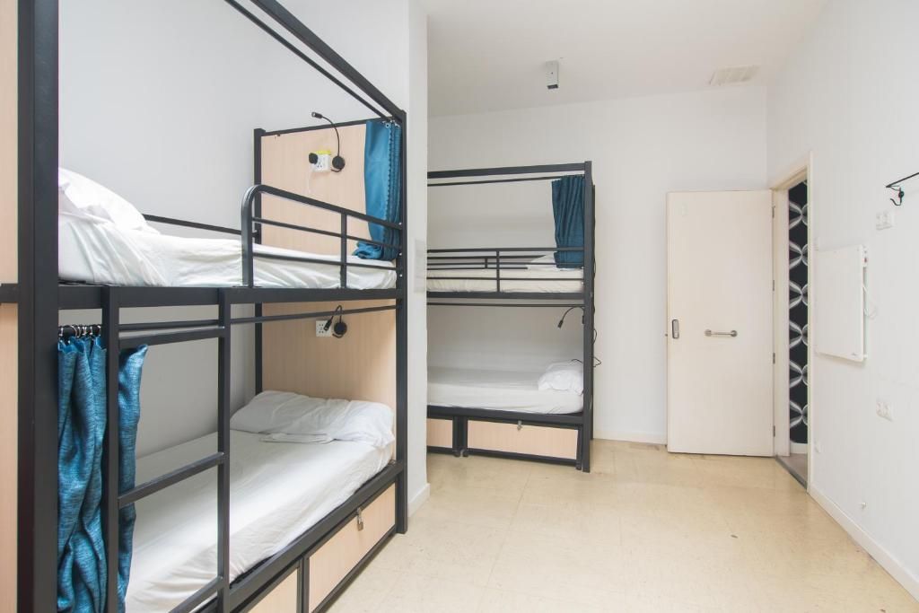 A room with four bunk beds and a door