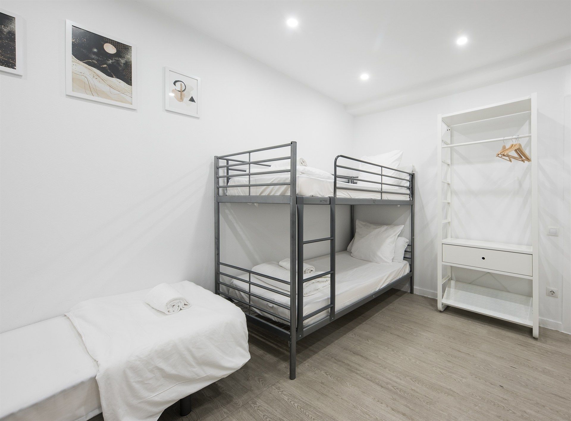 A bedroom with two bunk beds and a single bed.