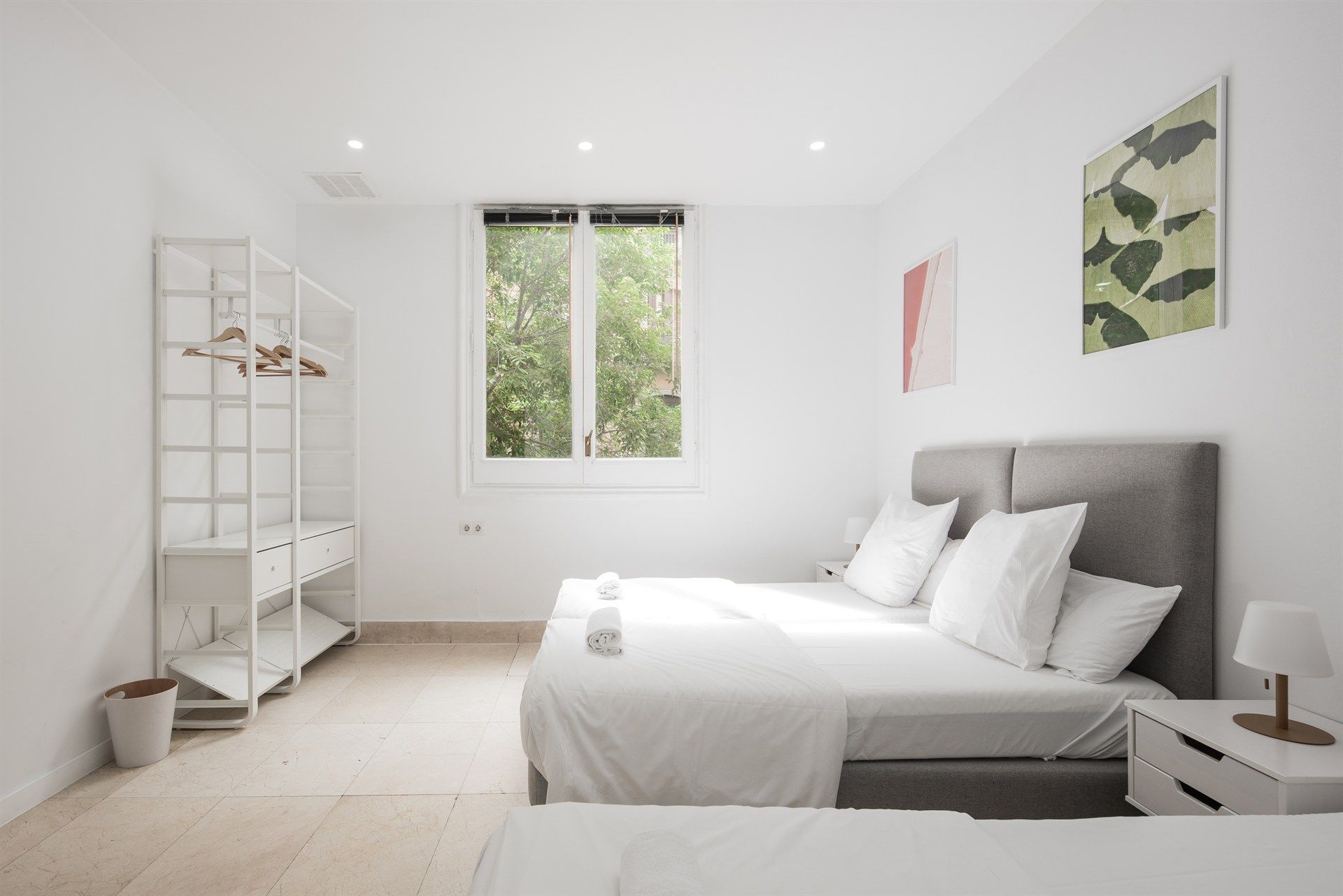 A bedroom with two beds and a window