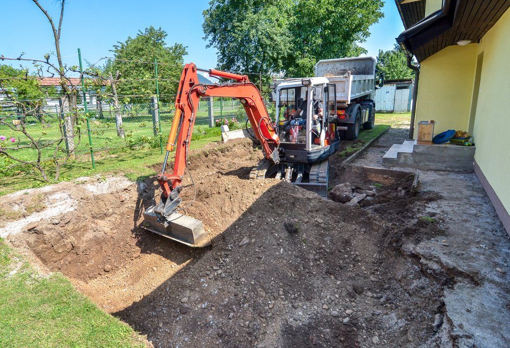 An Excavator Digging Beside a House — Unblock Pipe Clearing in Murwillumbah, NSW
